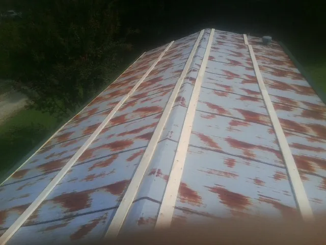 Rusted metal roof panels with new wood purlins before replacement — Storm Damage Roof Repair in Flintstone by Roofing Brothers