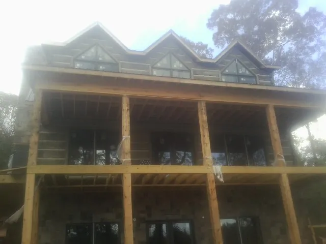 Dormers and porch framing on a large log home under construction — Roof Coating work by our crew in Flintstone
