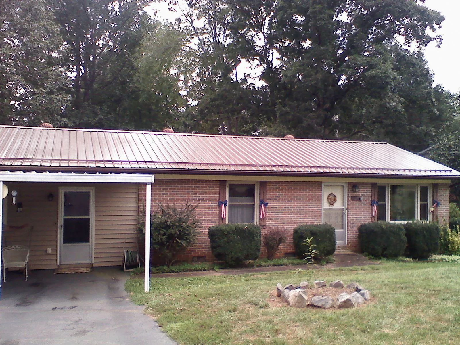 Bronze metal roof and carport on a brick ranch home — Roof Repair work by our crew in Flintstone
